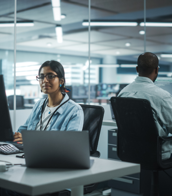 Employees in an office sitting at their desks working on their computers