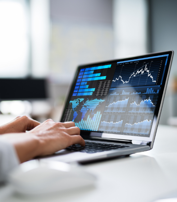 Person using a laptop that has graphs and financial modeling on the display
