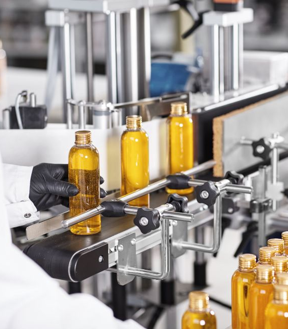 Selerant Devex PLM and regulatory compliance solutions for specialty chemical companies and chemical management amber colored bottles on conveyor belt