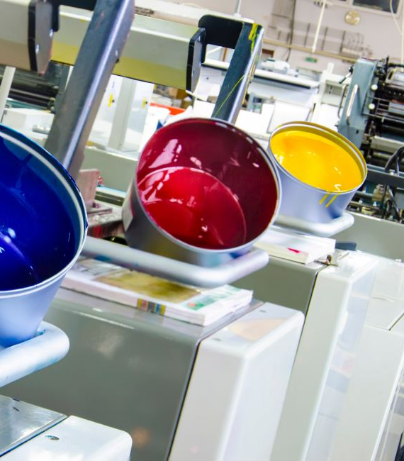 Selerant Devex PLM ERP integration Image 3 - Three large vats of paint in a facility, each in a different color of blue, red, and yellow