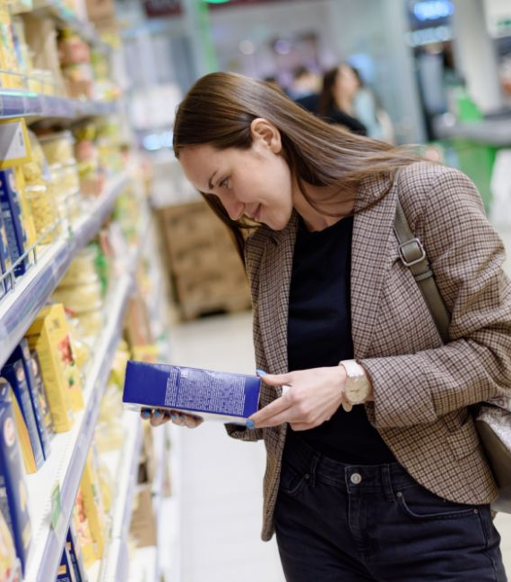 Selerant food and beverage product development and compliance woman looks at food product label in supermarket