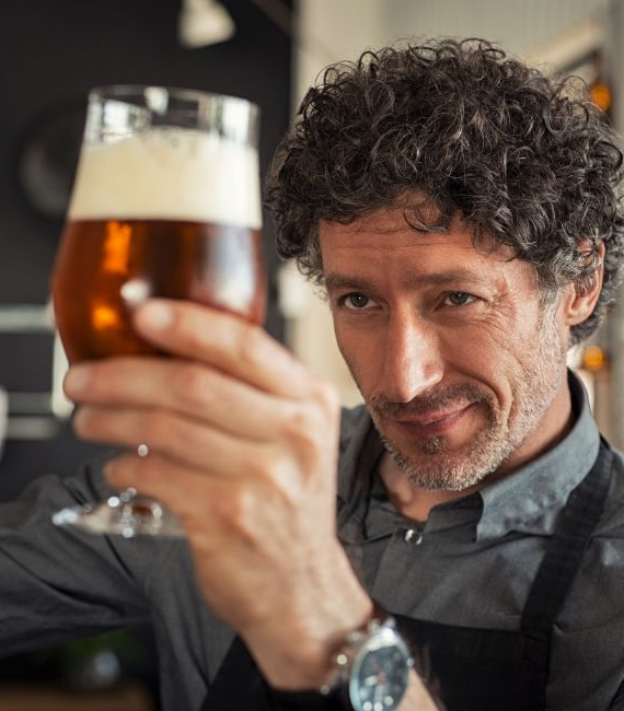 Selerant Devex PLM man holds up glass of beer