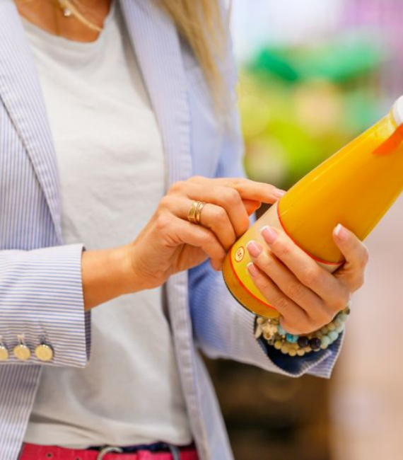 Selerant Devex PLM product data management software for process industries woman points at back label of a juice container