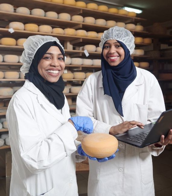 Selerant food and beverage compliance two women in hijabs and white coats pose with product in hand